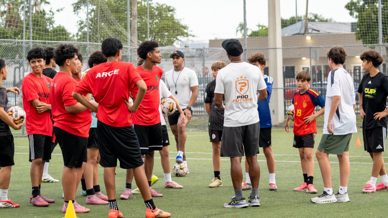 Entrenadores de ProFuture dando instrucciones a un grupo de jugadores en la cancha